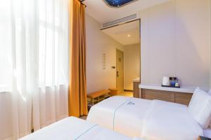 Letto o letti in una camera di Dequan Luxury Hotel National Exhibition Center Wangjing Bridge Branch The subway is right outside the door Coffee, fruits, snacks, a gym and a laundry room are provided for free in the lobby
