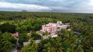 an aerial view of a pink building surrounded by trees at Sakthi River Resort in Pollāchi