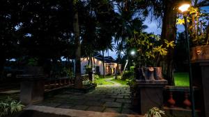 a walkway in front of a house at night at Sakthi River Resort in Pollāchi
