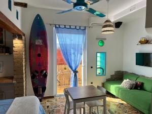 a living room with a couch and a table and a surfboard at Pompei Sunday Estate Exclusive Apartaments in Pompei