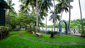 a park with palm trees and a roller coaster at Sakthi River Resort in Pollāchi