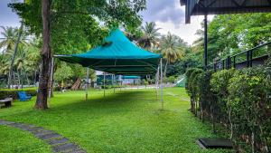 a blue tent hanging from a tree in a park at Sakthi River Resort in Pollāchi