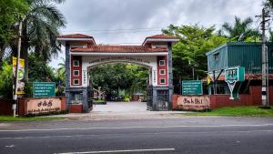 a building with an arch in front of a street at Sakthi River Resort in Pollāchi