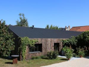 a wooden building with a black roof at Chambre d'hôtes pour 2 pers. avec petit-déjeuner inclus - FR-1-590-506 in La Ferté-Saint-Aubin