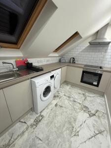 a kitchen with a washer and dryer on a marble floor at Riverside in London