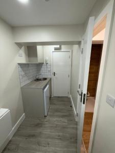 a small kitchen with a sink and a door at Riverside in London