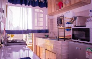 a kitchen with a sink and a microwave at Golden Cozy Homes Limuru in Limuru