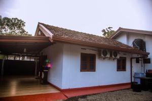 a small white house with a porch at Villa Number 6 in Weligama