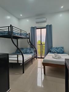 a bedroom with two bunk beds and a balcony at Greenwood Residences in Bacolod