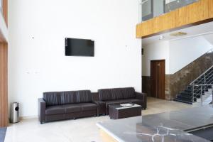 ein Wohnzimmer mit Sofa und Fernseher in der Unterkunft HOTEl MARKS INN in Munirābād