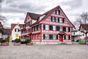 a large red and white building with a red door at Hotel Bären Amriswil in Amriswil