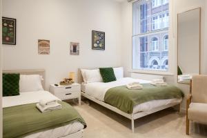 une chambre avec deux lits et une fenêtre dans l'établissement Grand Central Apartments - Perfect for Families - Contractors - Professionals, à Central Station