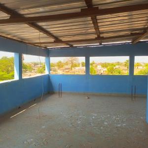 an empty room with blue walls and windows at Appartement chez Alioune in Tilel +3 photos