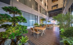 a wooden deck with tables and chairs in a building at Kyriad Hotel Foshan Nanhai Guangfo Smart City in Foshan
