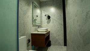 a bathroom with a sink and a shower at Sakthi River Resort in Pollāchi