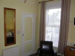 a living room with a chair and a window at Kingswinford Guest House in Paignton