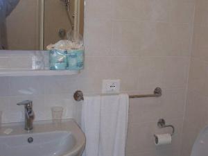 a bathroom with a sink and a white towel at Cottage in Intra with Lake and Mountain Views in Verbania +31 photos
