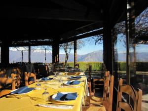 a dining room with tables and chairs with mountains in the background at Cottage in Intra with Lake and Mountain Views in Verbania