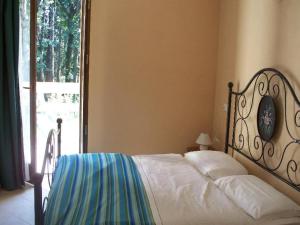 a bedroom with a bed and a large window at Cottage in Intra with Lake and Mountain Views in Verbania