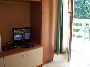 a television sitting on a counter in a room with a window at Cottage in Intra with Lake and Mountain Views in Verbania
