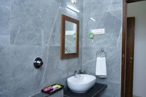 Un baño con un lavabo blanco y un espejo. en HOTELMARKINn, en Munirābād 20 fotos más