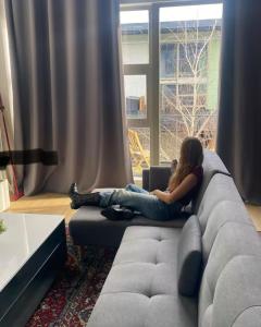 a woman sitting on a couch in a living room at Red 4 x 4 in Camarma de Esteruelas