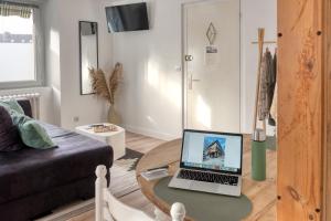 a living room with a table with a laptop on it at Le Cosy in Lannion