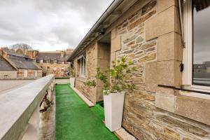 a balcony with green grass and a plant at Le Cosy in Lannion