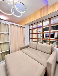een woonkamer met een bank en een groot raam bij City View Suite in Manilla