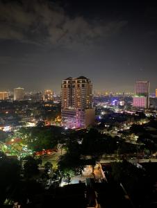 een skyline van de stad 's nachts met een hoog gebouw bij City View Suite in Manilla