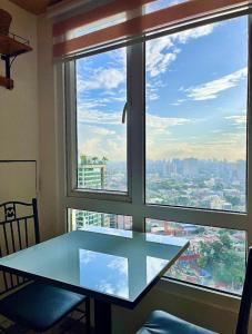 een glazen tafel voor een raam met uitzicht bij City View Suite in Manilla