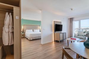 a hotel room with a bed and a living room at INNSiDE by Meliá Alicante Porta Maris in Alicante