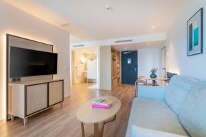 a living room with a blue couch and a tv at INNSiDE by Meliá Alicante Porta Maris in Alicante