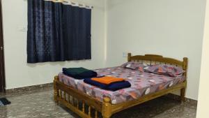 a bedroom with a wooden bed with a window at Dream Oasis Home Stay in Gokarna