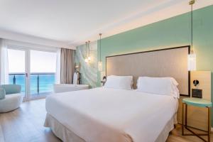 a bedroom with a large white bed and a large window at INNSiDE by Meliá Alicante Porta Maris in Alicante