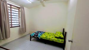 a small bed in a room with a window at Teratak Anies Semi-D Bypass Homestay Kuantan in Kuantan