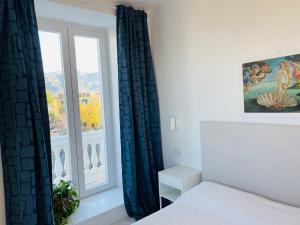 a bedroom with a bed and a window at Casa Torre a Sorrento con parcheggio gratuito in Sorrento
