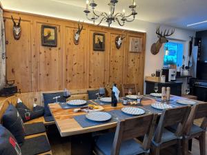 a dining room with a wooden table and chairs at Exklusives Berg-Bijou mit Bergblick mit privaten Wellnessbereich Hot Tube und Sauna -Hunde herzlich Willkommen mit eingezäunten Grundstück in Scuol