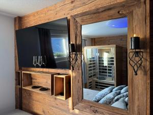 a large mirror in a room with a bed at Exklusives Berg-Bijou mit Bergblick mit privaten Wellnessbereich Hot Tube und Sauna -Hunde herzlich Willkommen mit eingezäunten Grundstück in Scuol