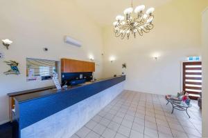 a large kitchen with a blue counter and a chandelier at Quality Inn Penrith Sydney in Penrith