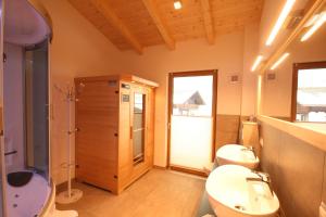 a bathroom with two toilets and a shower and a sink at Großglockner Goldried Chalet in Kals am Großglockner +31 photos