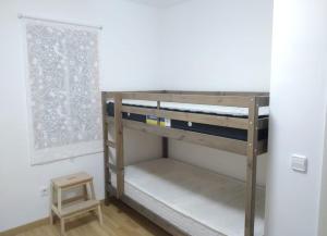 a bunk bed in a room with a small stool at Apartamento cerca de Barcelona in Viladecáns