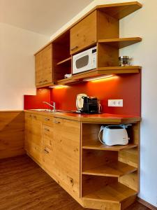 een keuken met houten kasten en een magnetron bij Ferienwohnung Gabriel in Rust