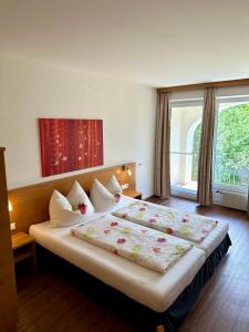 een slaapkamer met een groot bed met kussens en een raam bij Ferienwohnung Gabriel in Rust