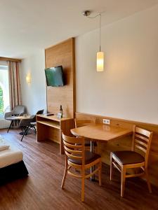 een kamer met een tafel, stoelen en een tv bij Ferienwohnung Gabriel in Rust