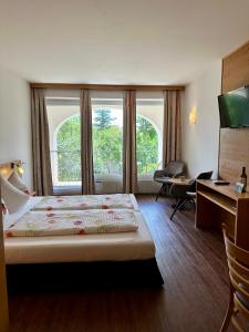 een slaapkamer met een bed, een bureau en een raam bij Ferienwohnung Gabriel in Rust +16 foto's