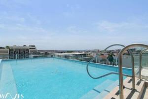 a large swimming pool on top of a building at 1 Br. w5th avenue view Steps from the beach in Playa del Carmen