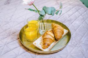 a plate of croissants and glasses of orange juice at Victoria Park Studio 11 - Free Parking, WiFi, Near Town Centre, Free DisneyPlus, Prime & Netflix in Leamington Spa
