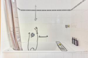 a bath tub with a shower in a bathroom at Traumferienwohnung Domblick 2 I Altstadtnähe I Zentrale Lage I Balkon mit Domblick I Stilvoll in Limburg an der Lahn +17 photos