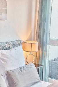 Traumferienwohnung Domblick 2 I Altstadtnähe I Zentrale Lage I Balkon mit Domblick I Stilvoll في ليمبورغ ان دير لان: سرير مع مصباح بجوار النافذة